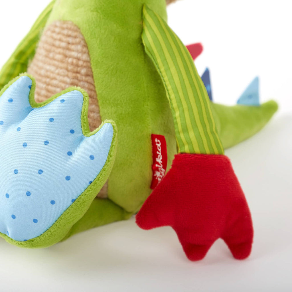 Close-up of a green dinosaur toy with red feet and blue spotted tail on a white background
