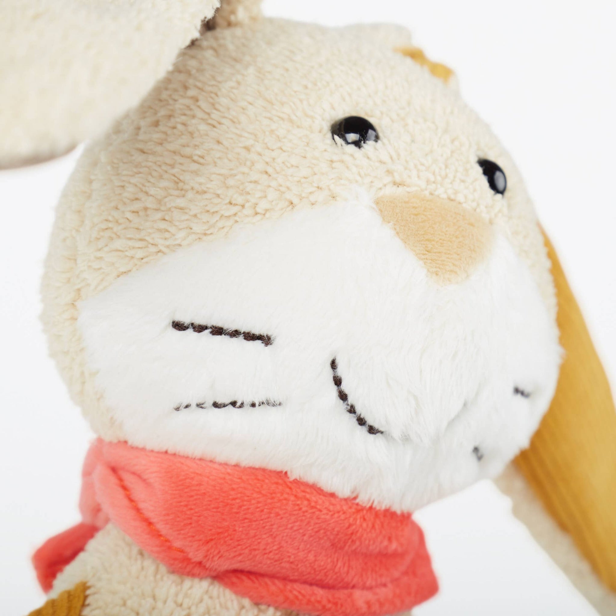 Close-up of a plush toy with a red scarf on a white background
