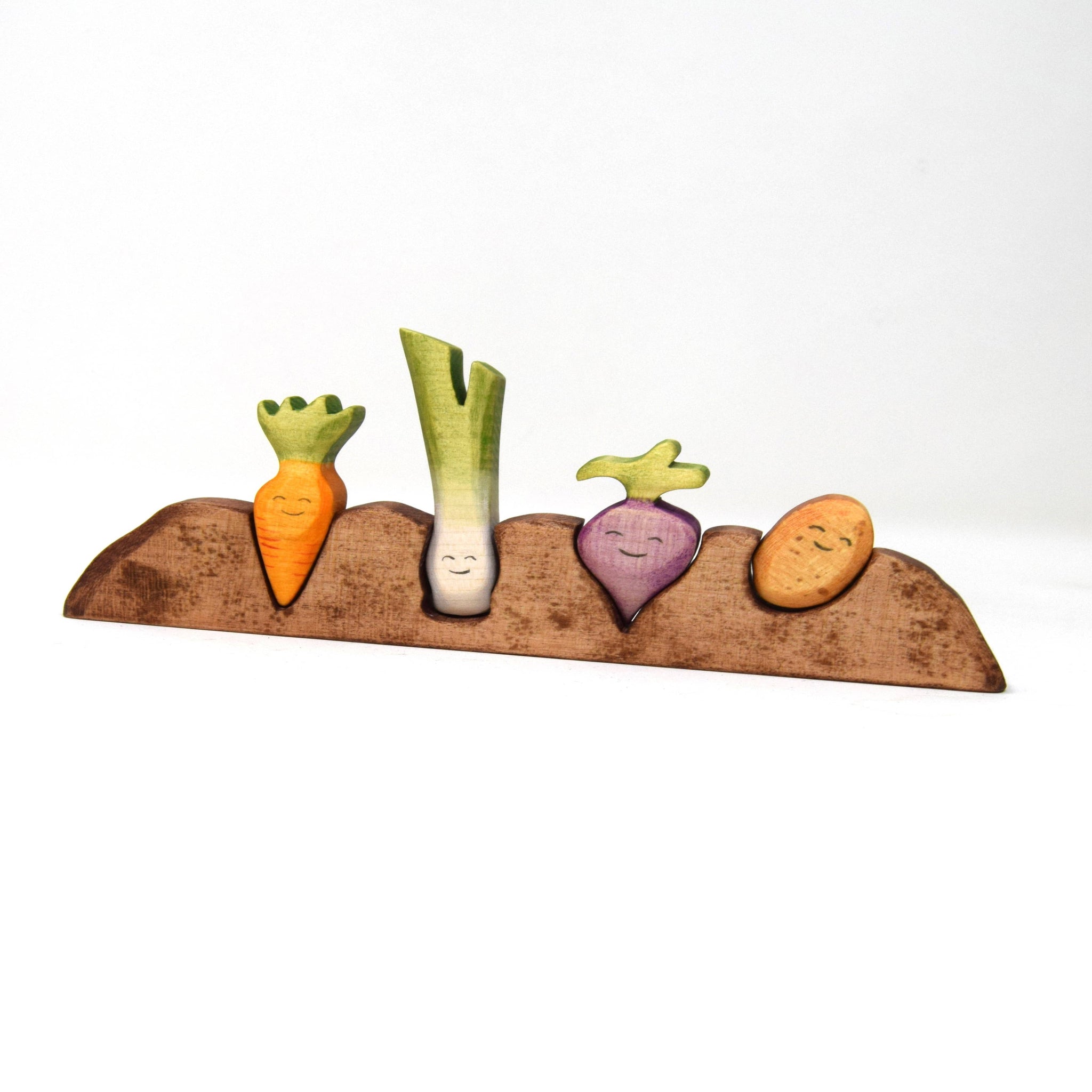 Set of ceramic vegetable-shaped salt and pepper shakers on a wooden base with a white background
