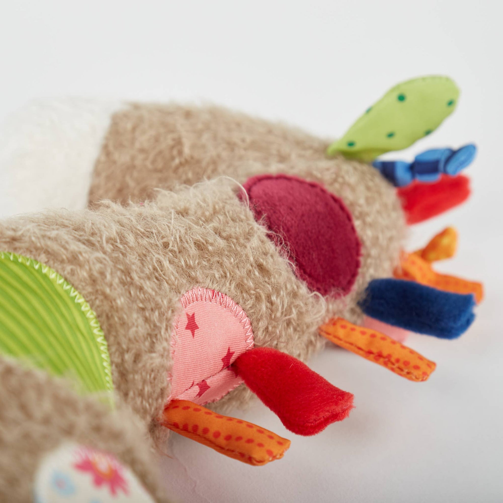 Colorful baby toy with soft textures on a light background