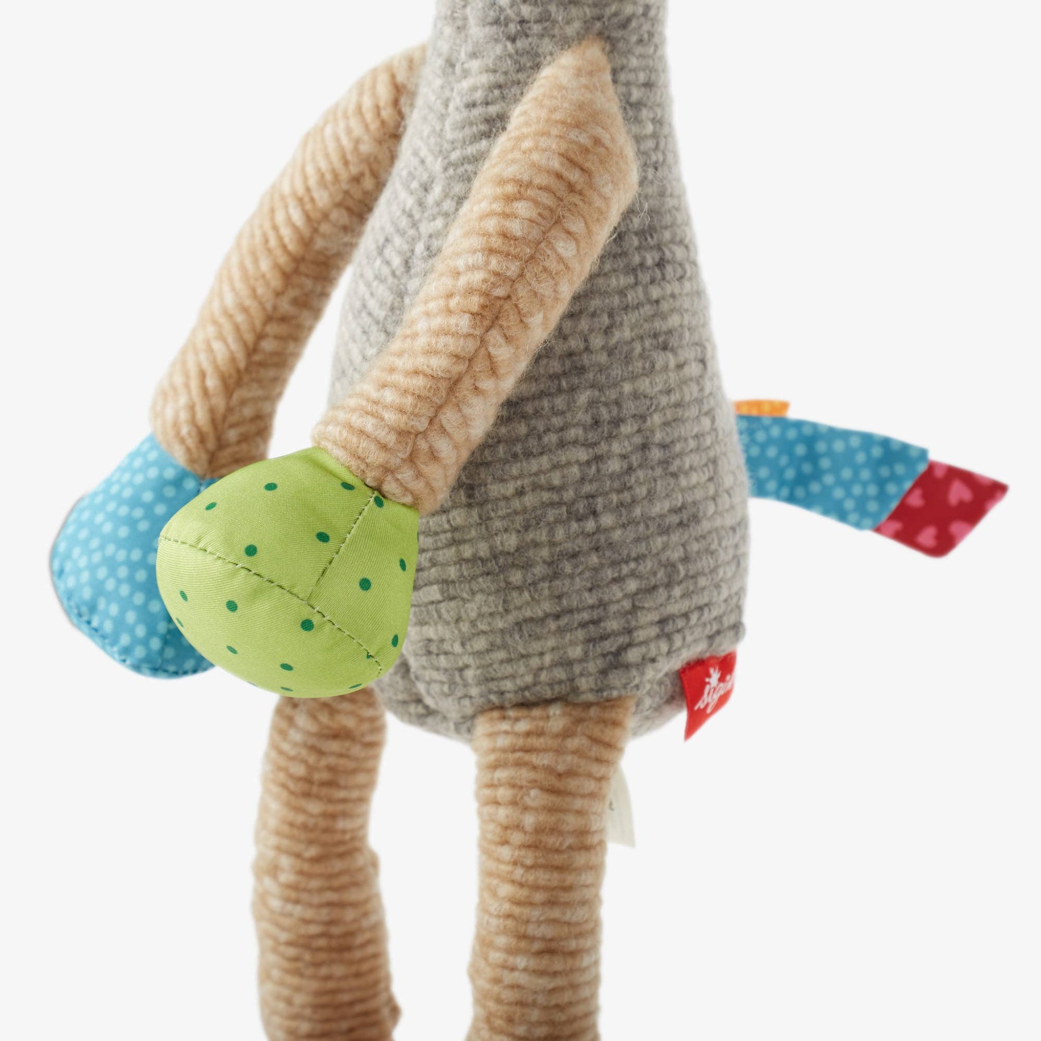 Plush toy with a green polka dot ball and colorful accents on a white background