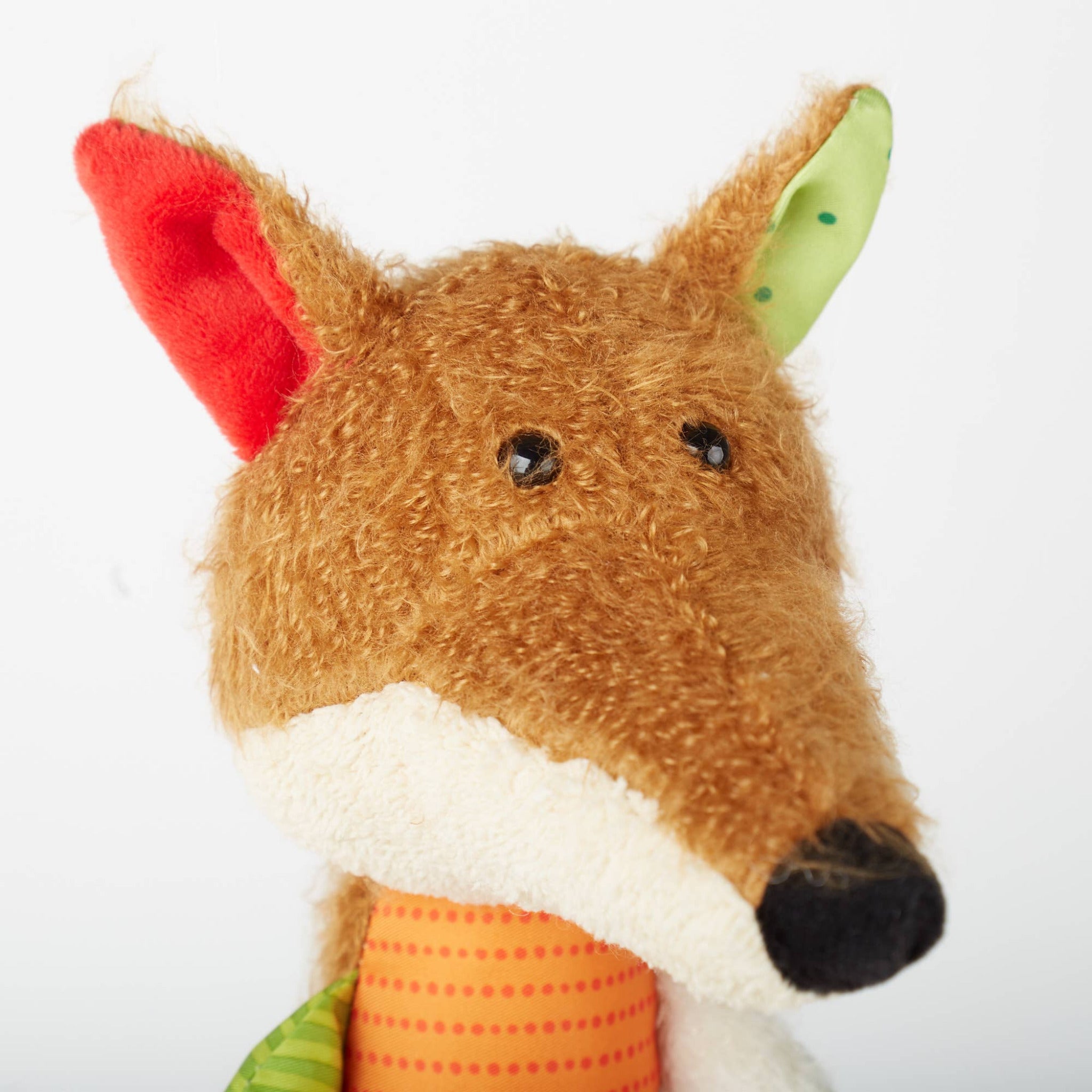 Plush toy fox head with a white muzzle and red ears on a white background