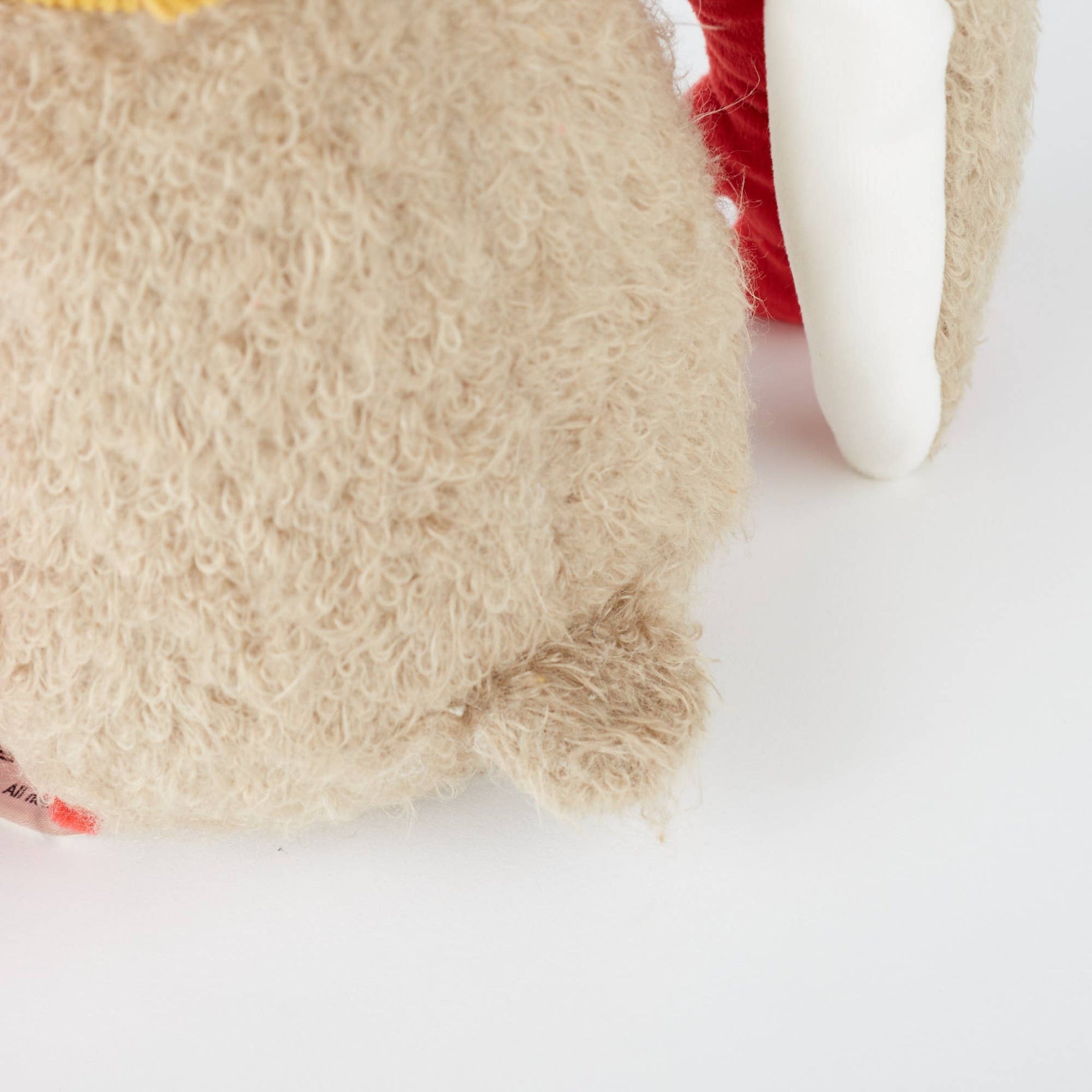 Close-up of a plush toy with beige fur on a white background