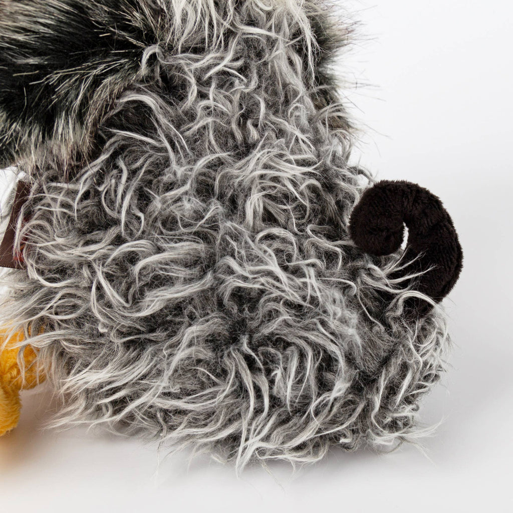 Close-up of a plush toy with a gray beard and black hat on a white background