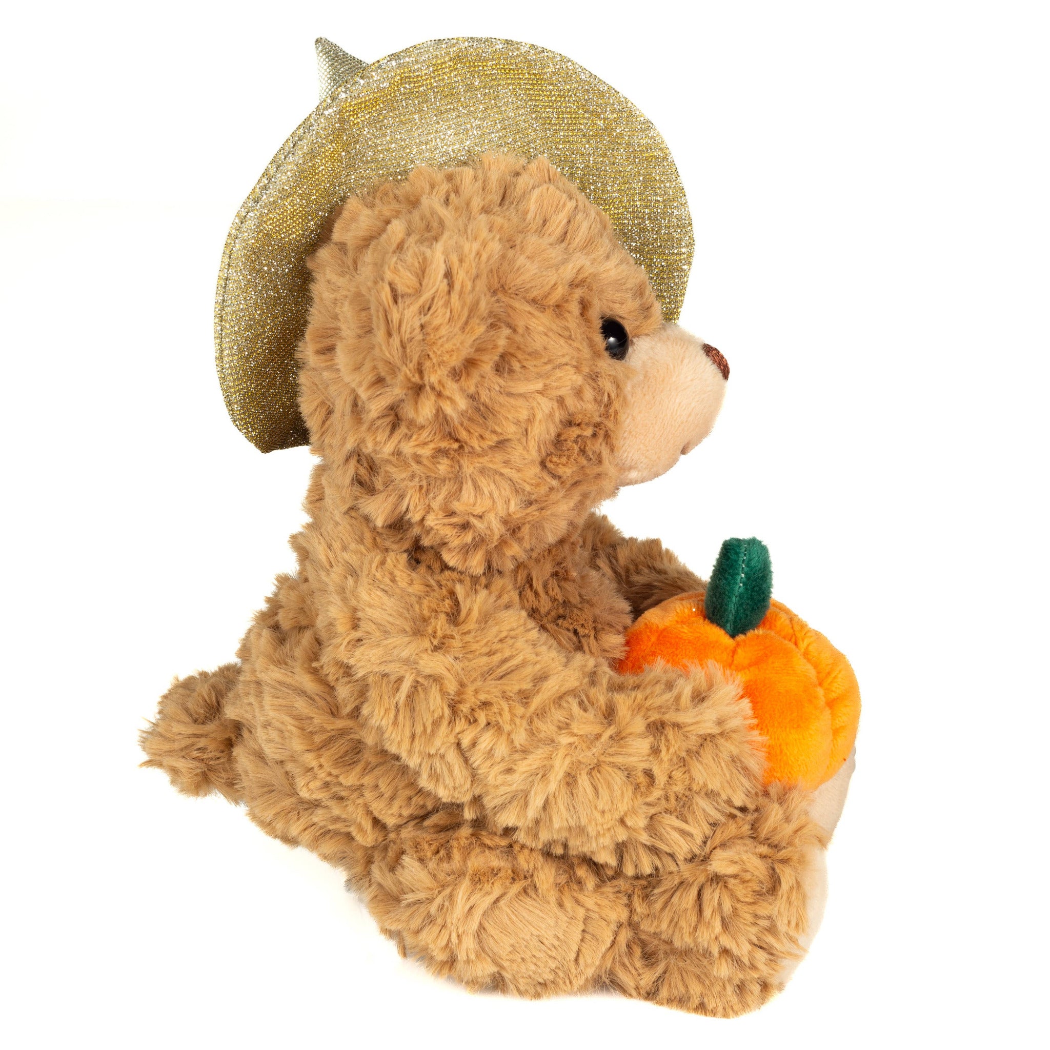 Teddy bear wearing a gold glittery hat and holding a small pumpkin on a white background
