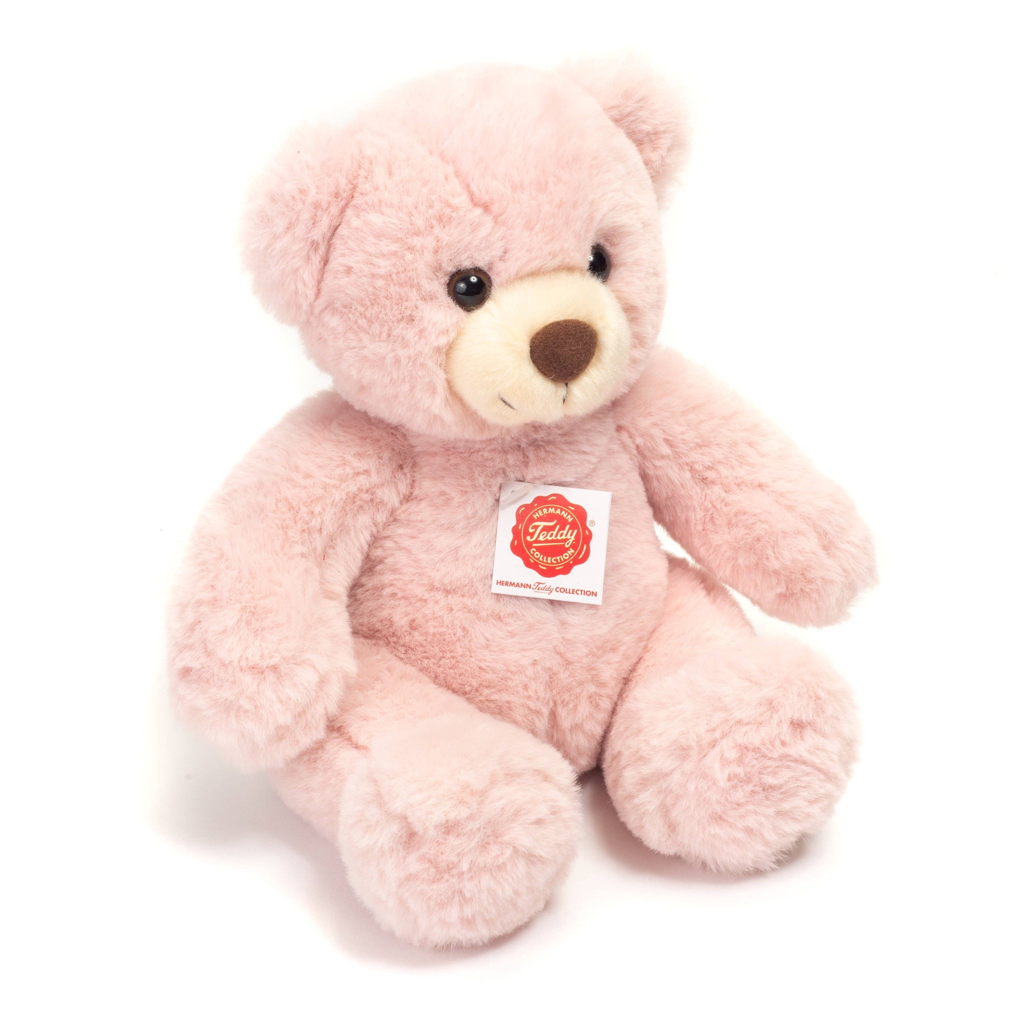Pink teddy bear with a visible tag on a white background