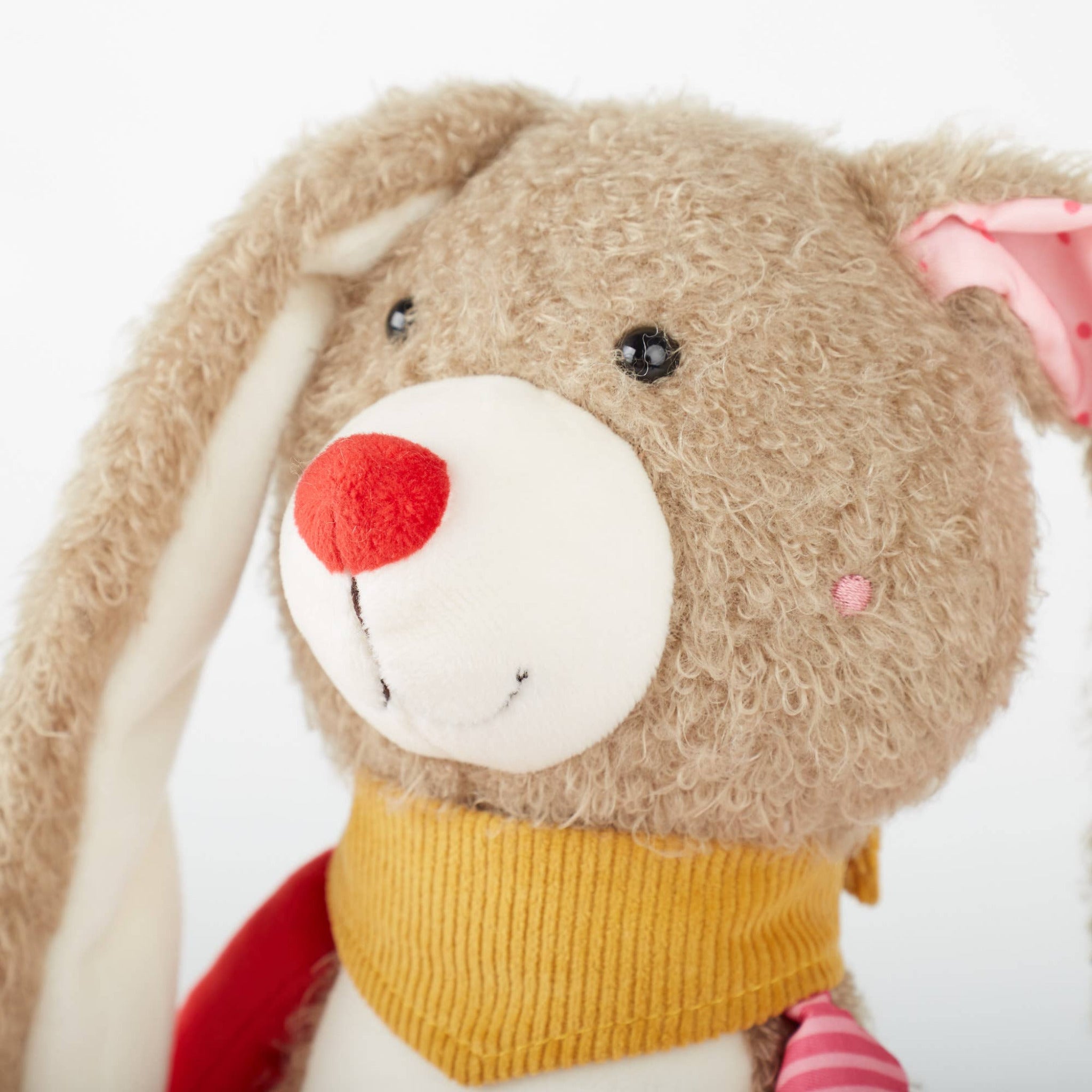 Plush toy with a red nose and yellow scarf on a white background