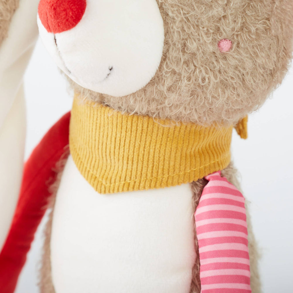 Close-up of a plush toy with a yellow sweater and red and pink accents on a white background