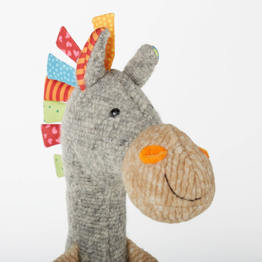 Plush toy resembling a character with a colorful hat on a white background