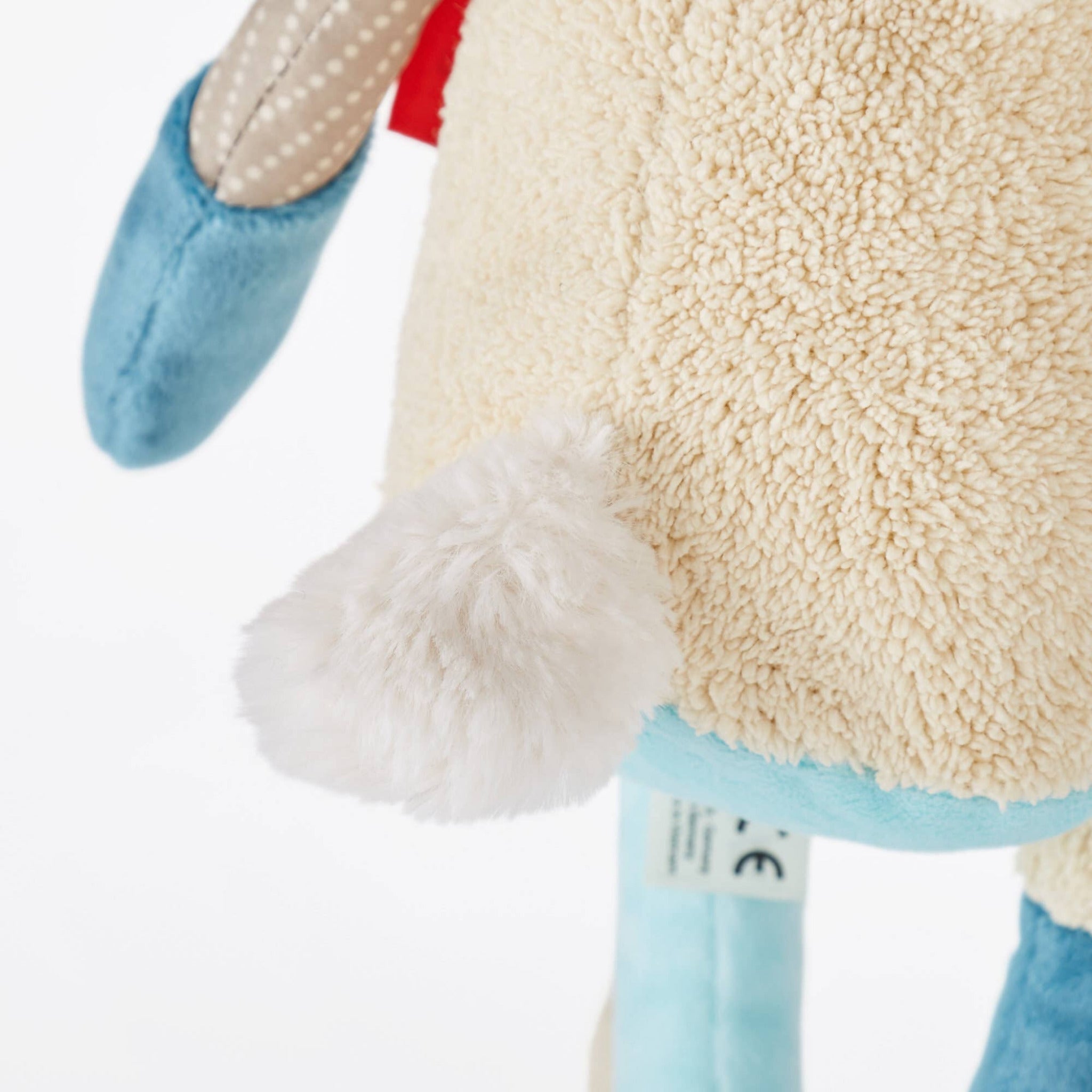 Close-up of a plush toy with a visible brand tag on a white background