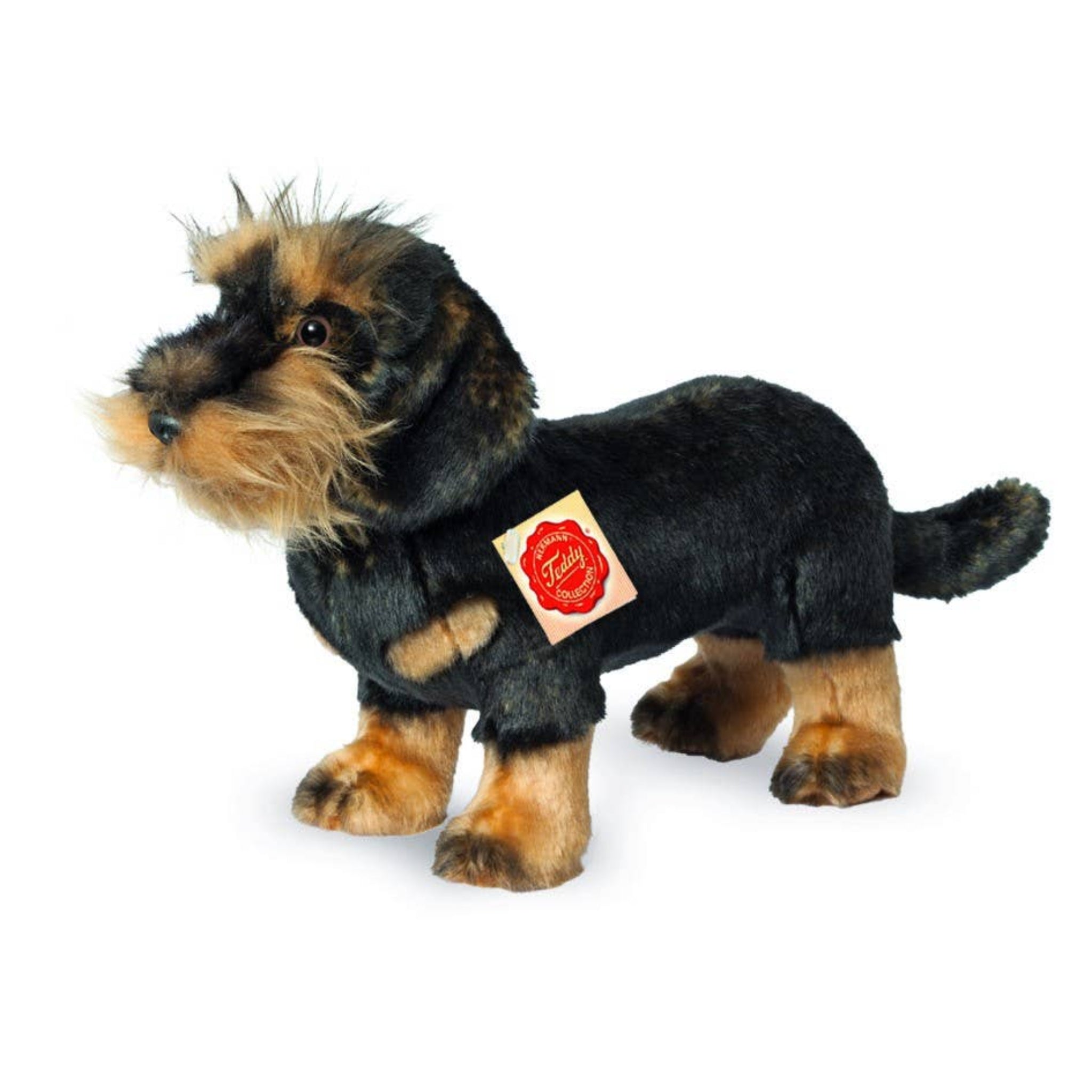 Stuffed dog toy with a black coat and tan face on a white background