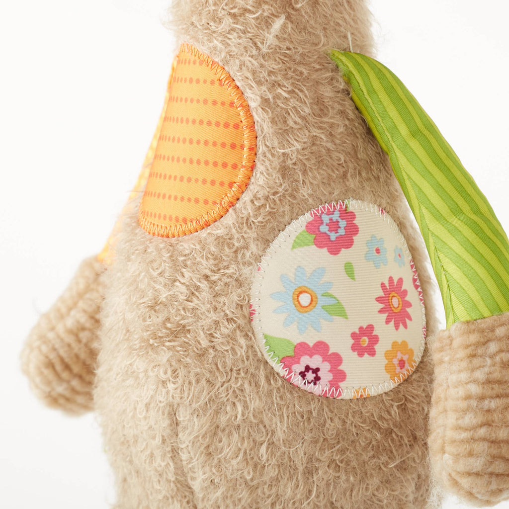 Close-up of a teddy bear with colorful patches on a white background