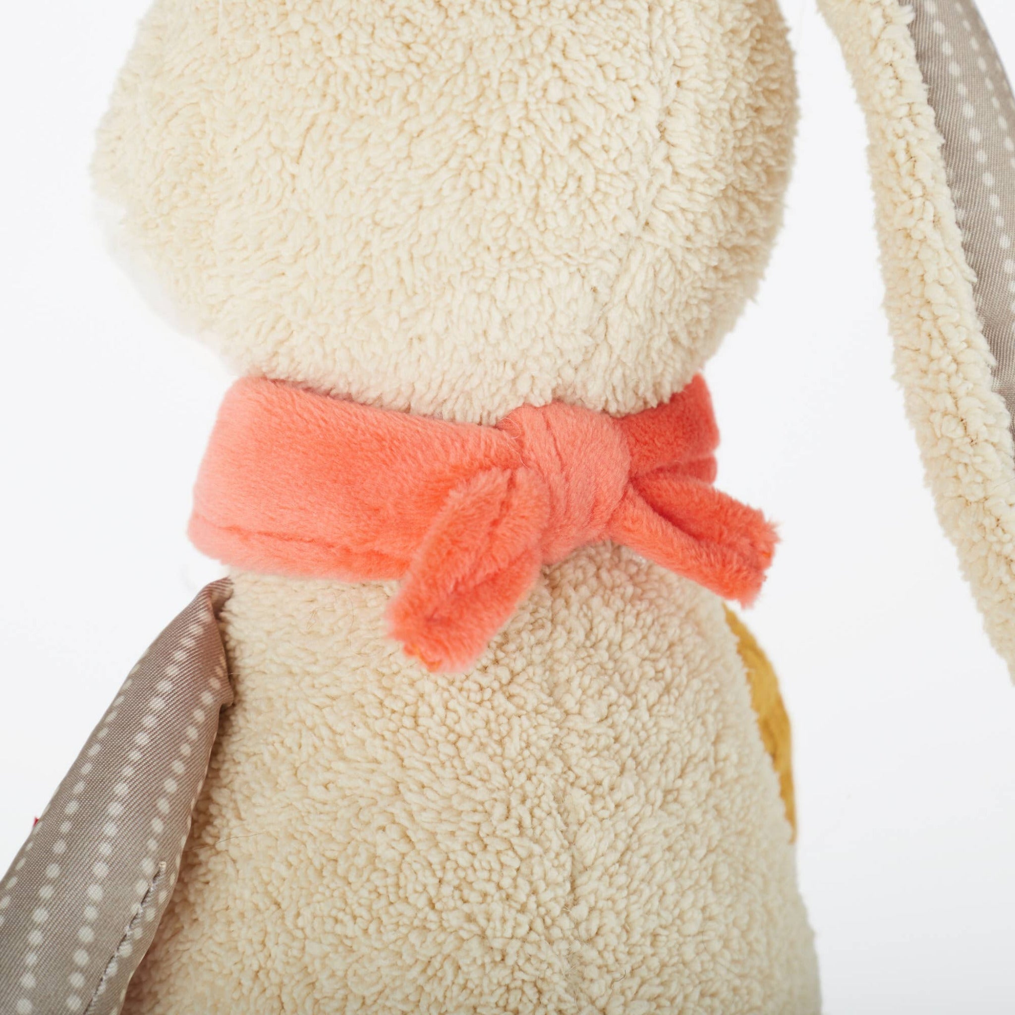 Close-up of a plush toy with a pink bow on a white background