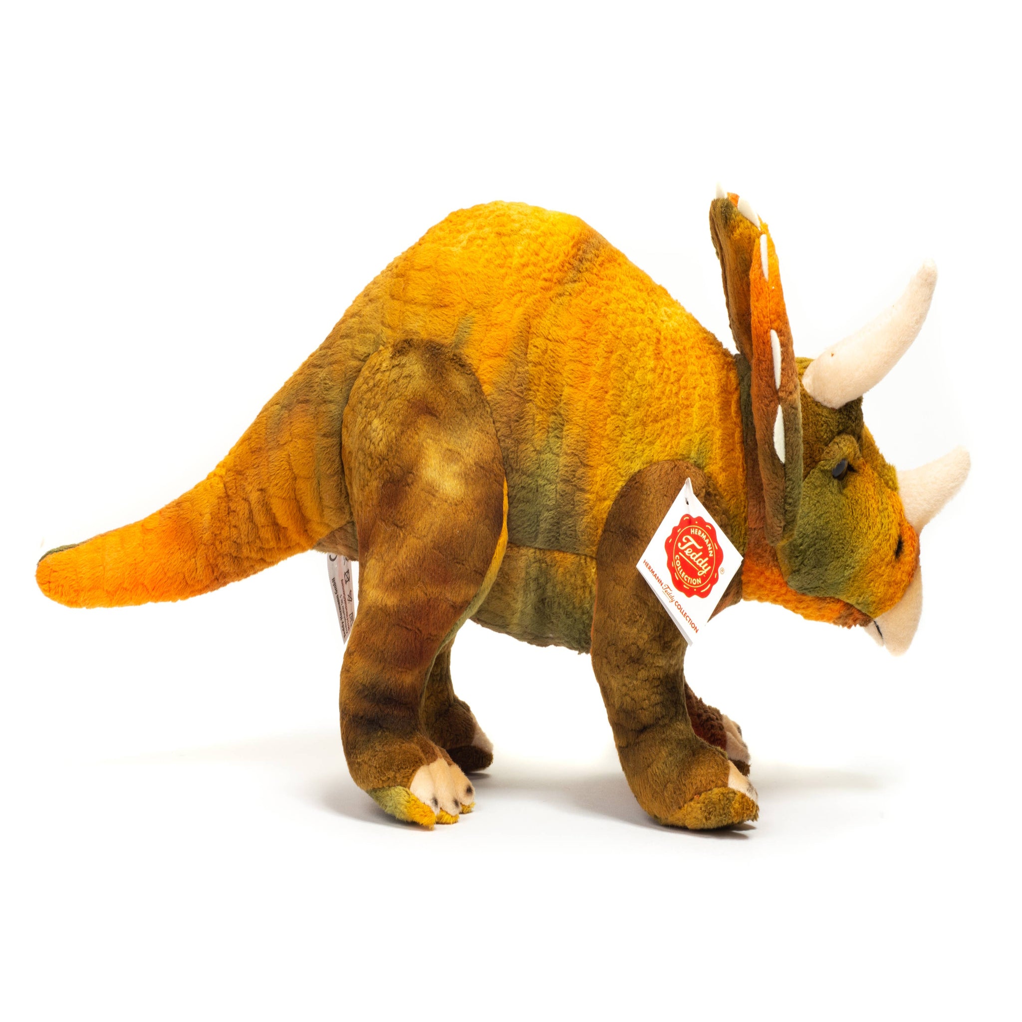Plush triceratops toy with a tag on a white background