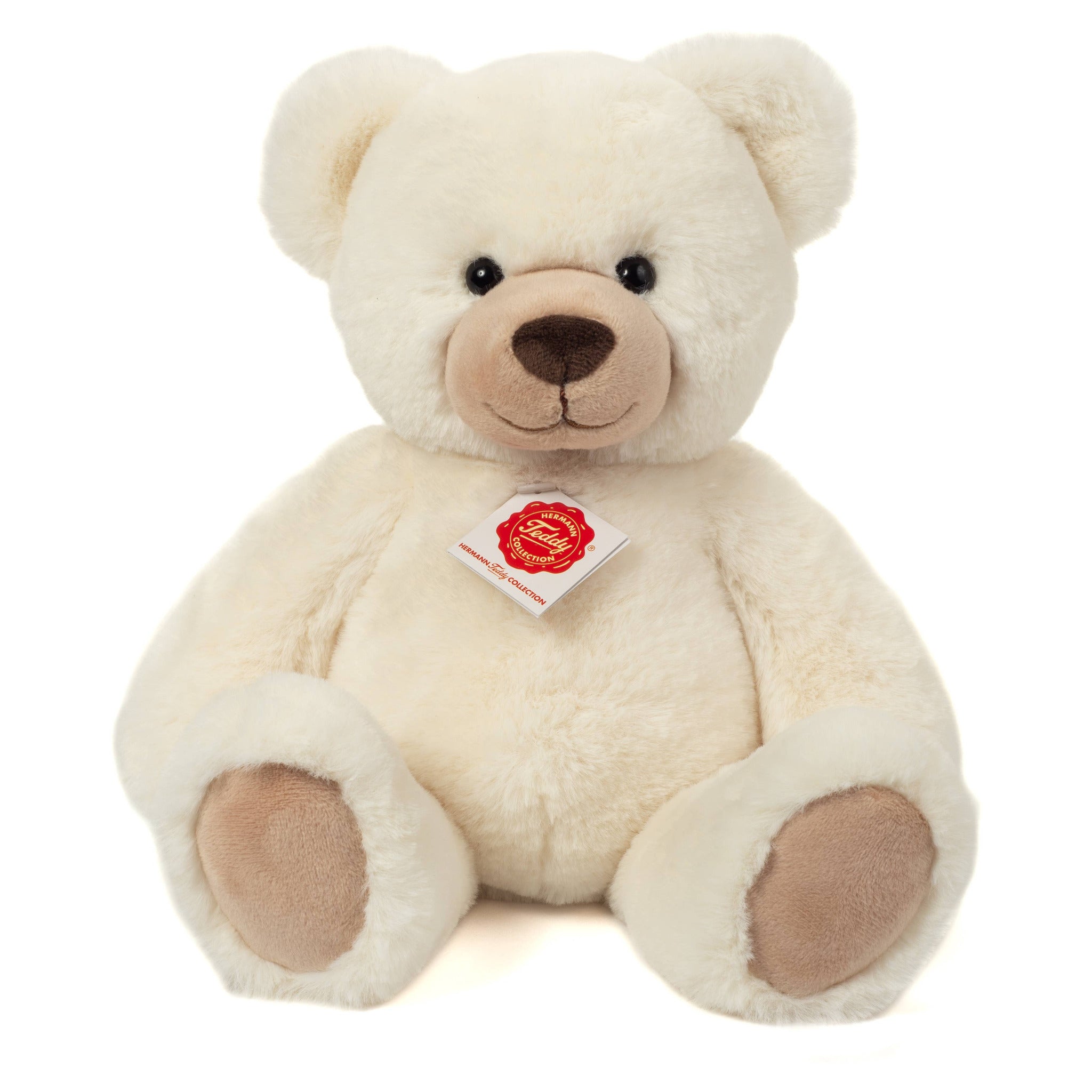 Cream-colored teddy bear with a visible tag on a white background