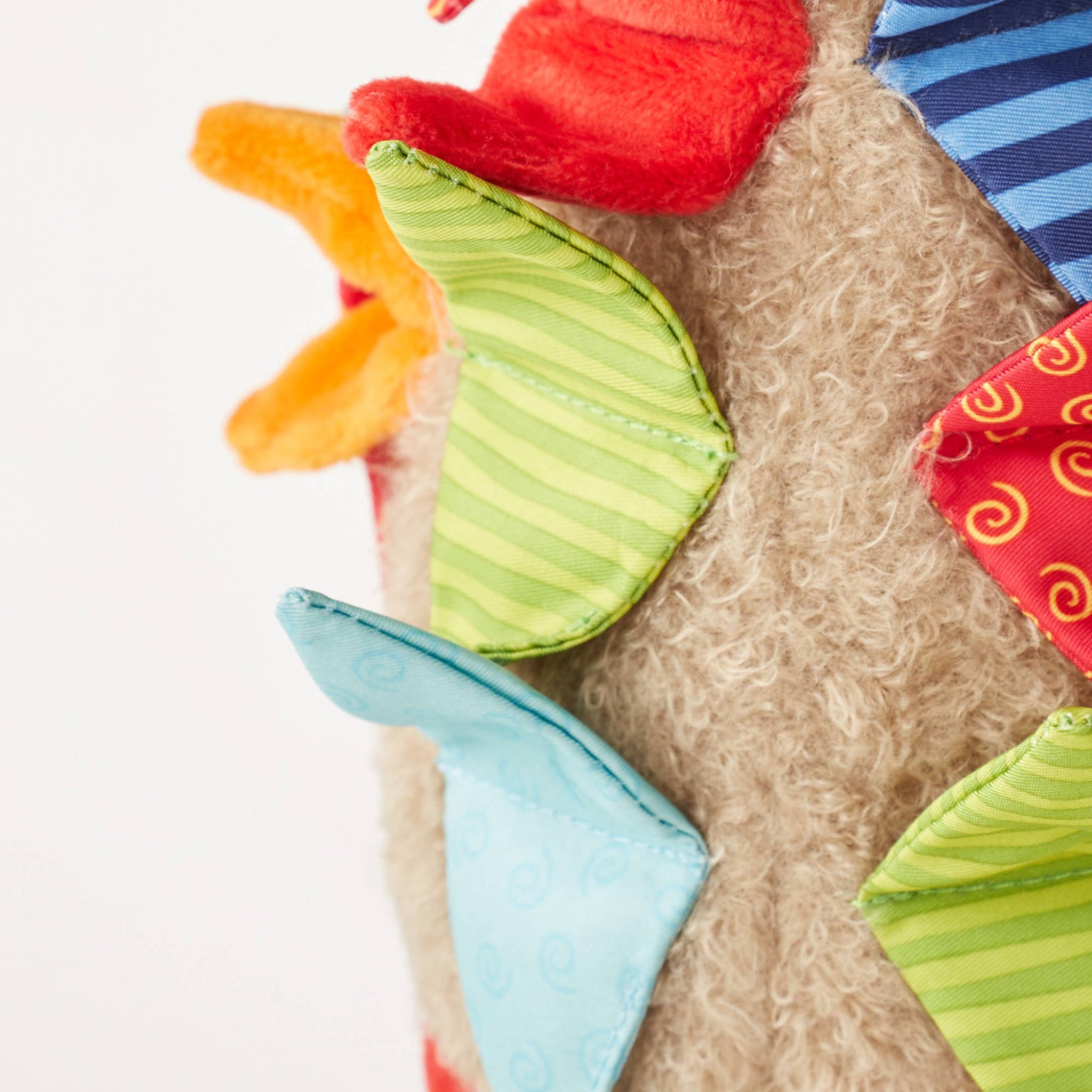 Close-up of a soft toy with colorful geometric shapes on a white background