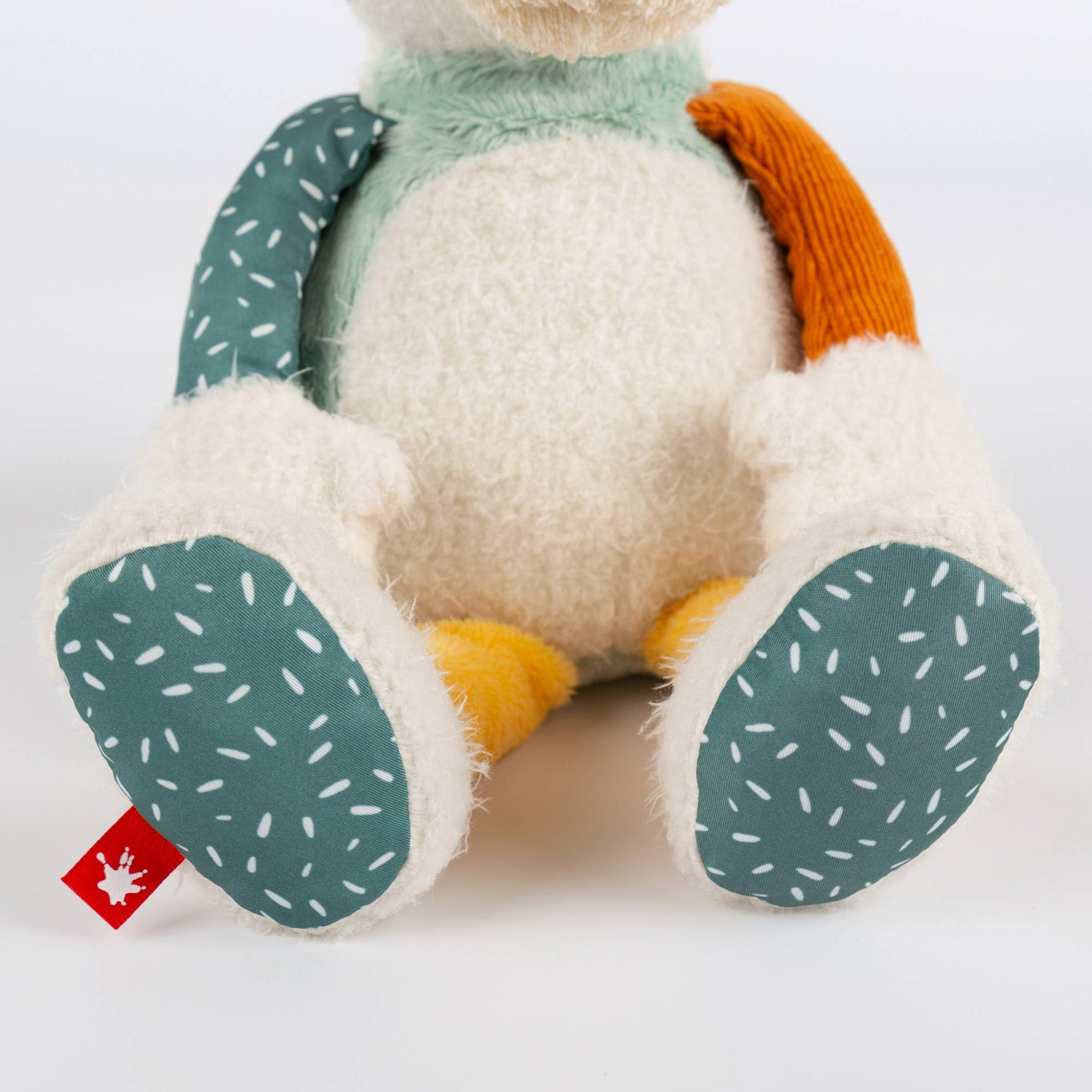 Plush toy with green paw pads and a backpack on a white background
