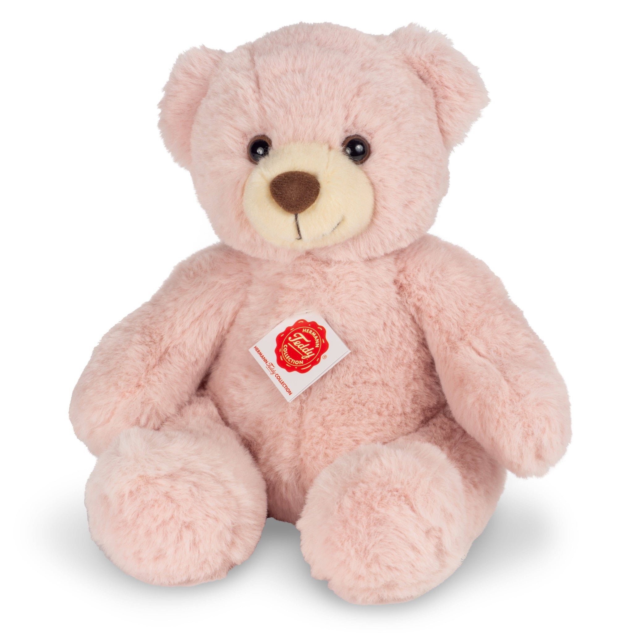 Pink teddy bear with a visible brand label on a white background