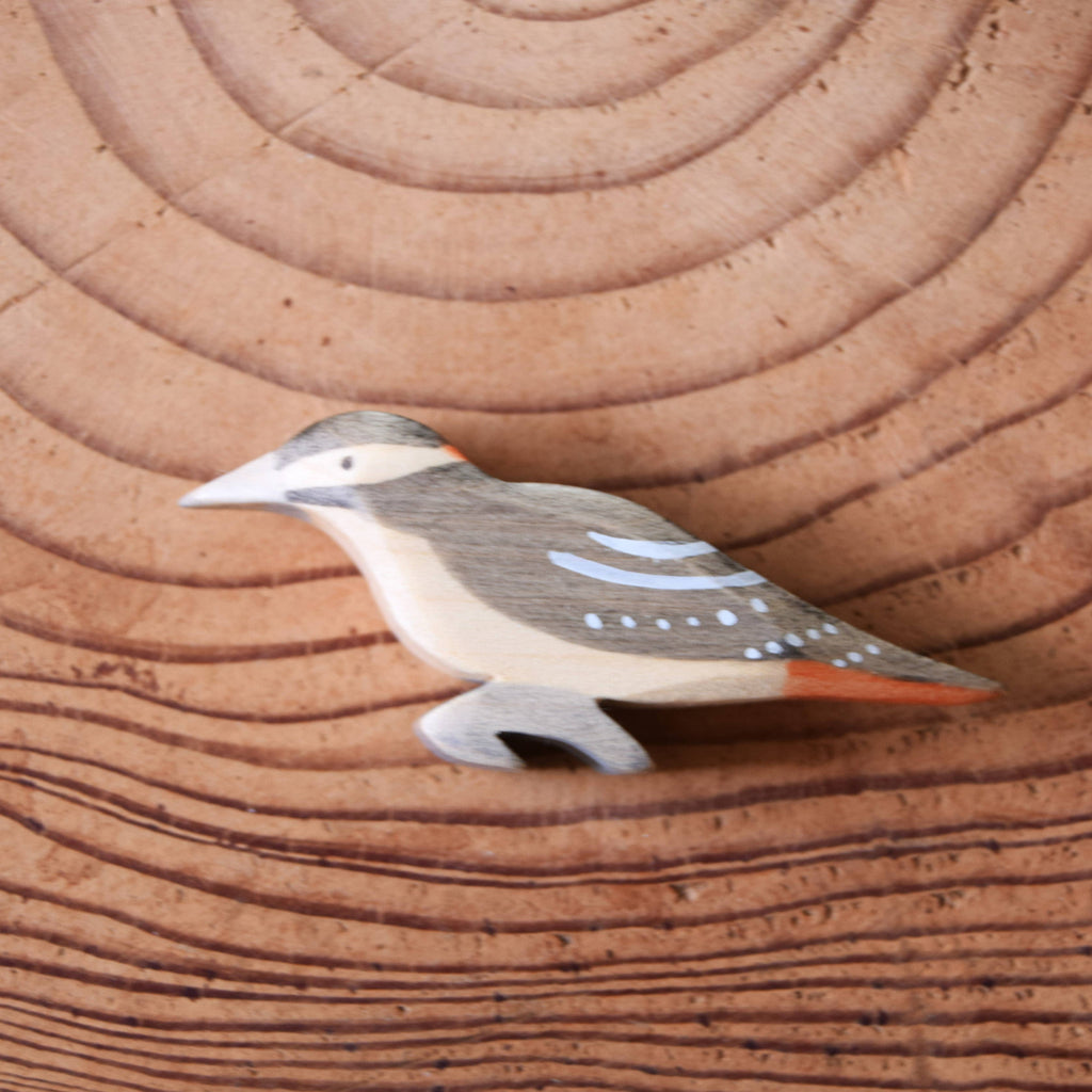 Wooden bird figurine on a wooden surface