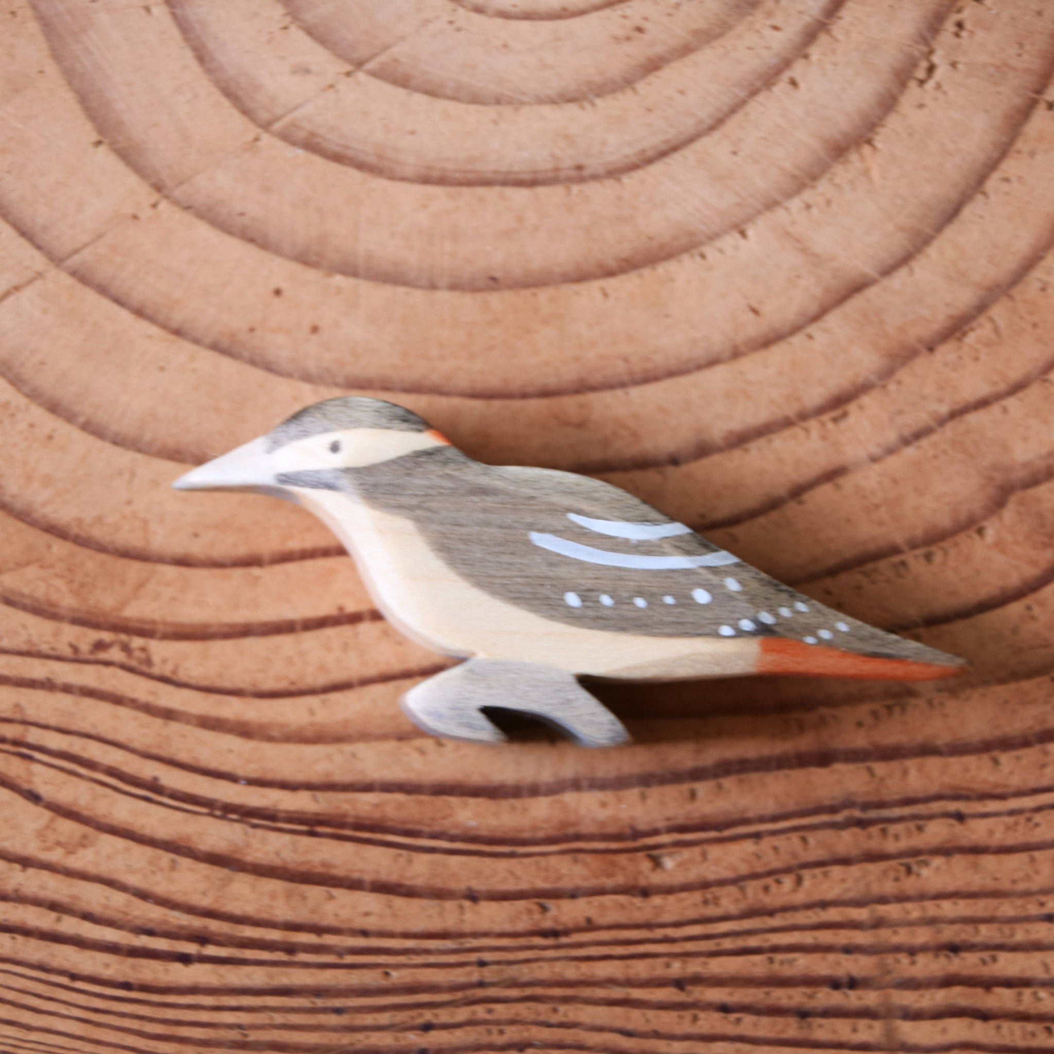 Wooden bird figurine on a wooden surface