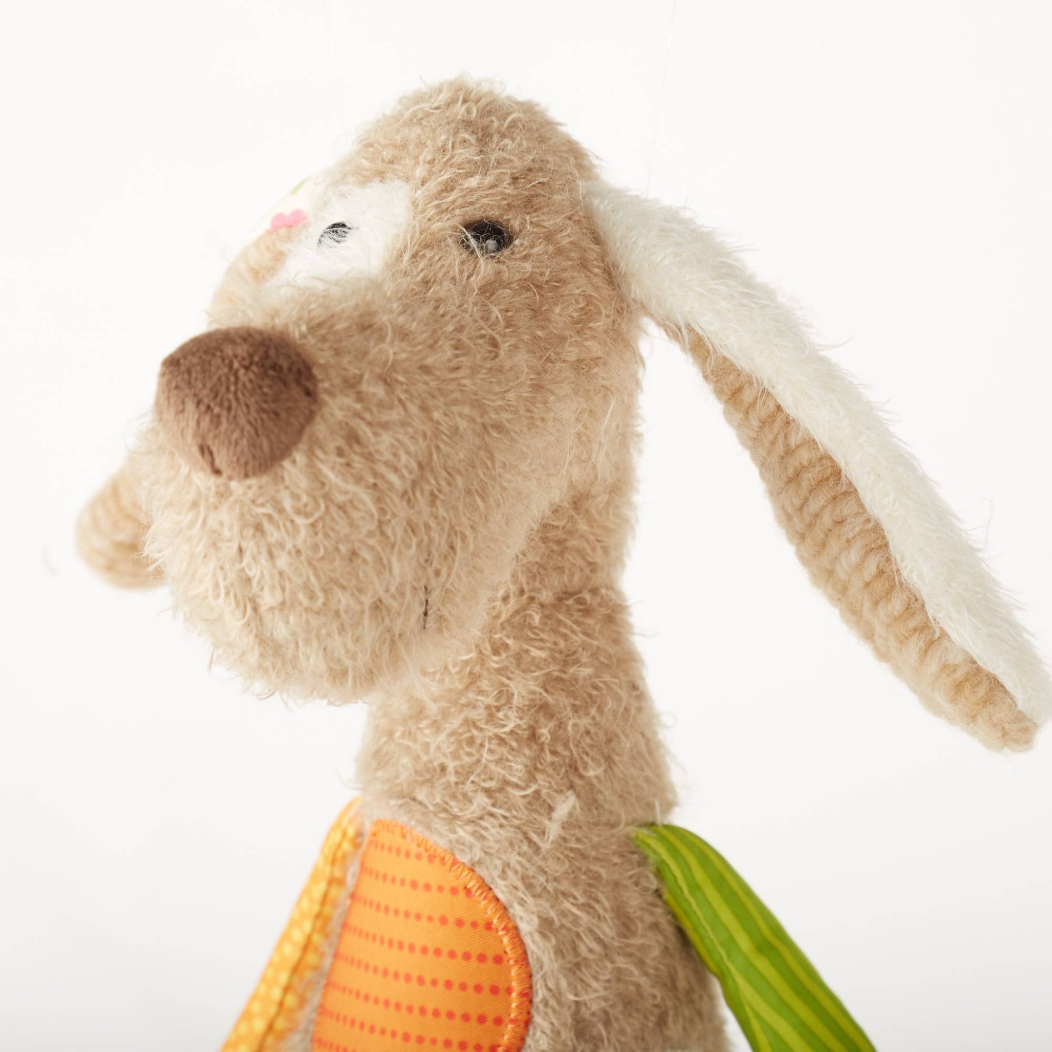 Plush toy rabbit with a carrot on a white background