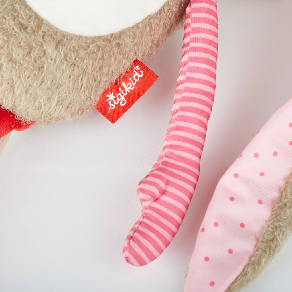 Close-up of a plush toy with pink and red striped and polka dot elements, featuring a Stiglitz label.
