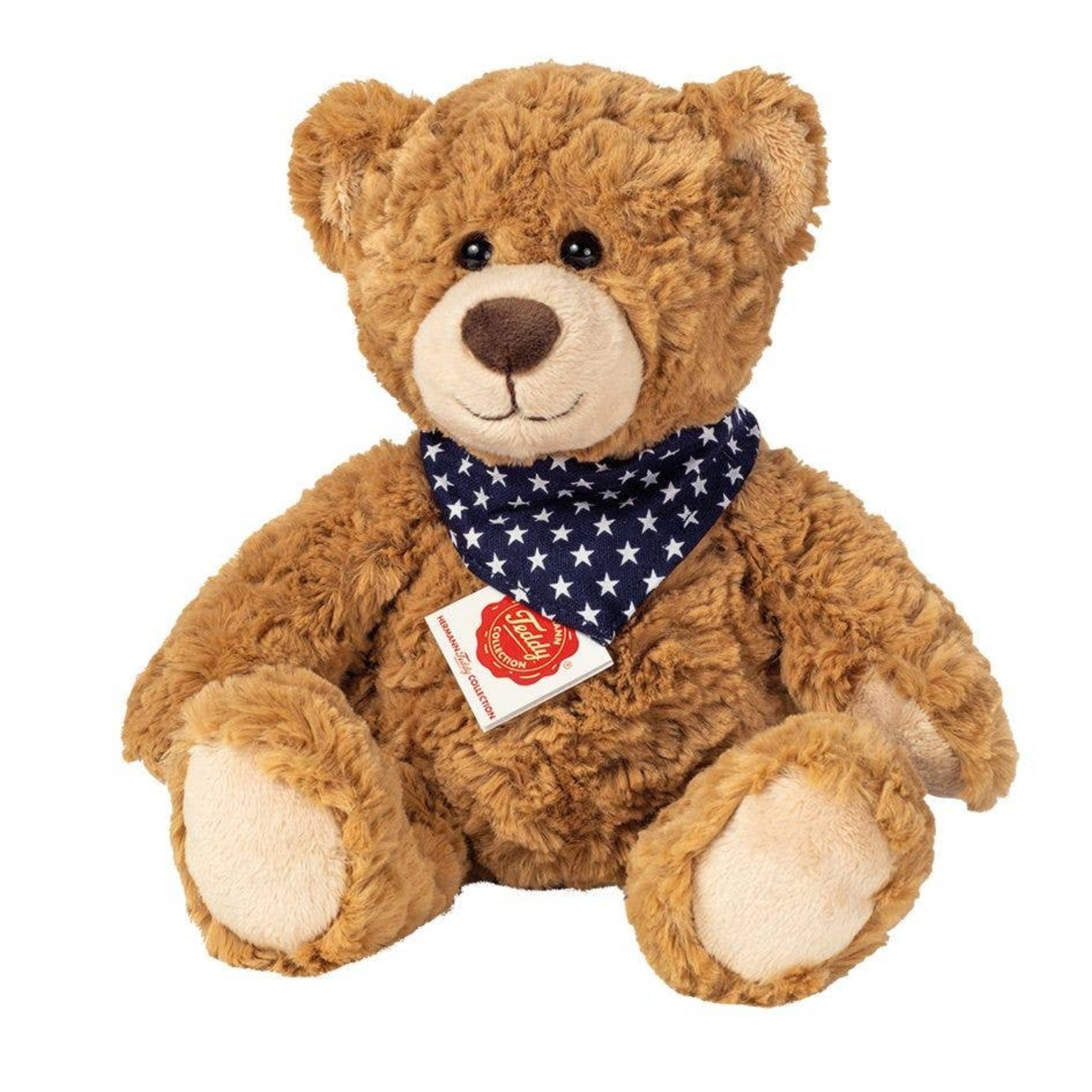 Brown teddy bear with a blue bandana featuring white stars on a white background