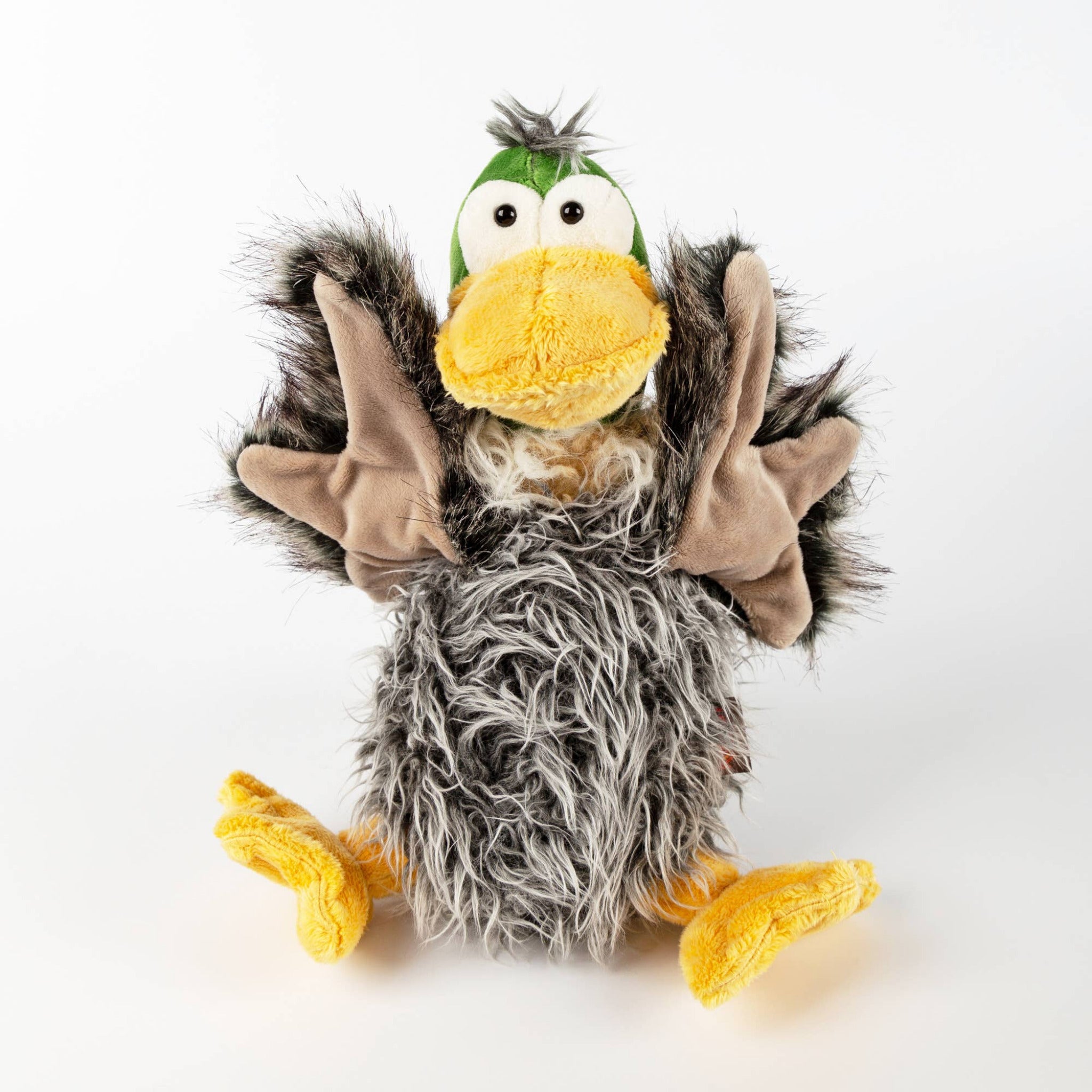 Plush toy resembling a bird with gray feathers, yellow beak, and feet on a white background